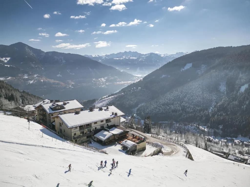 Berghotel Jaga Alm aan de piste met besneeuwde bergen